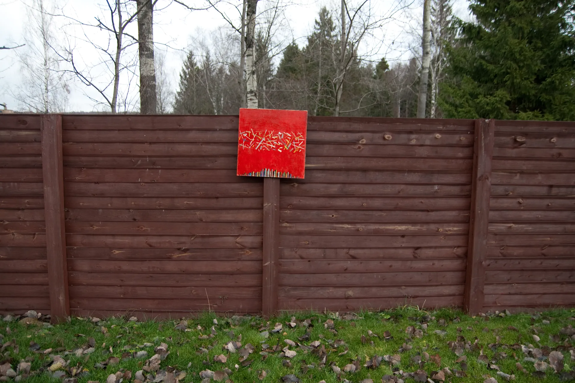 Artwork against a wooden fence